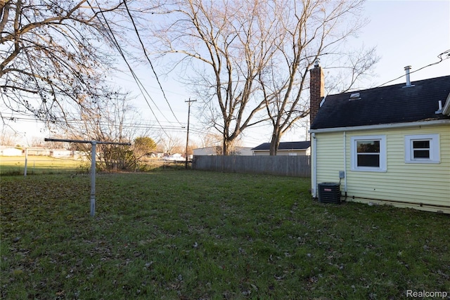 view of yard featuring central air condition unit and fence