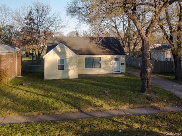 view of front of property with a front lawn and fence