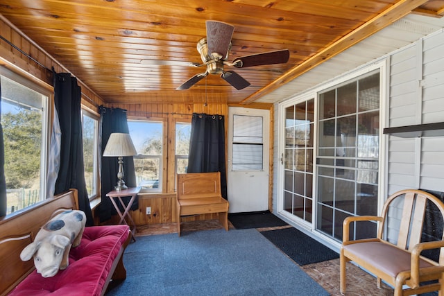 sunroom featuring wooden ceiling and a ceiling fan