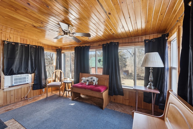 sitting room featuring wooden ceiling, wooden walls, cooling unit, and ceiling fan