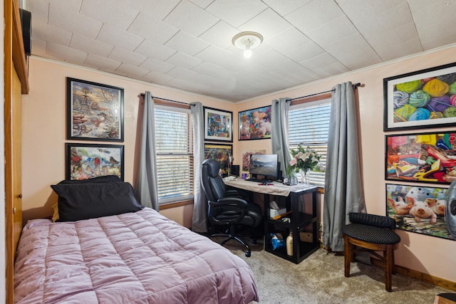 carpeted bedroom with multiple windows, crown molding, and baseboards