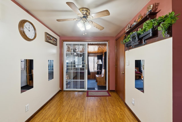 unfurnished room featuring a ceiling fan, baseboards, and wood finished floors