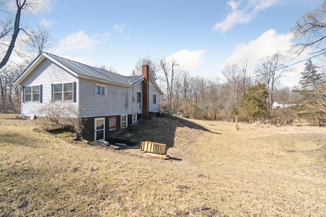 view of home's exterior featuring metal roof and a chimney