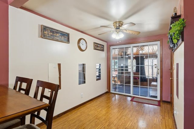 dining space with light wood-style flooring, a ceiling fan, and baseboards