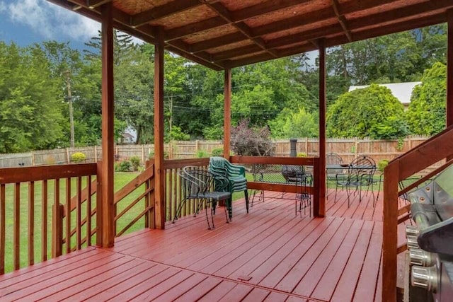 wooden terrace with a yard, outdoor dining area, and a fenced backyard