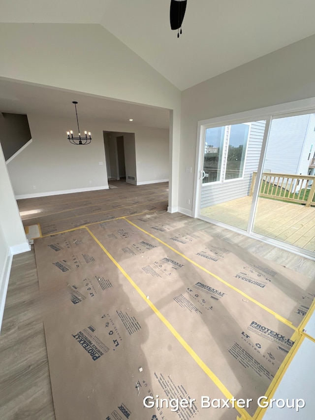 11328 Shoreline Dr Unit 118, Allendale, MI 49401 - unfurnished living room with vaulted ceiling, a chandelier, baseboards, a ceiling fan, and wood finished floors
