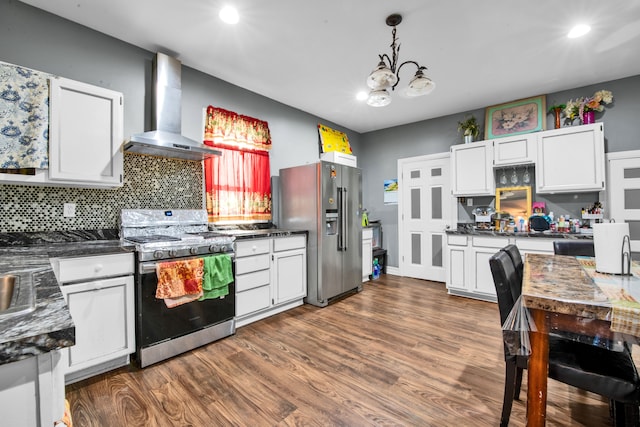 kitchen with dark countertops, stainless steel appliances, dark wood-type flooring, and wall chimney range hood