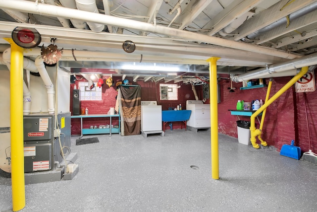 basement with heating unit, plenty of natural light, and washing machine and clothes dryer