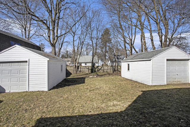 view of yard featuring a garage, an outdoor structure, and fence