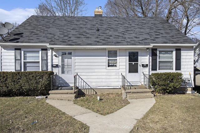 view of front of house with a chimney, entry steps, and a shingled roof