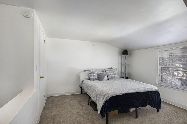 carpeted bedroom with baseboards and lofted ceiling