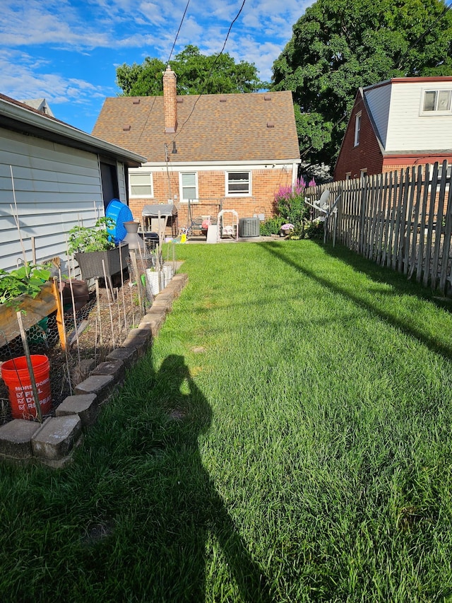 view of yard featuring a garden, cooling unit, and fence