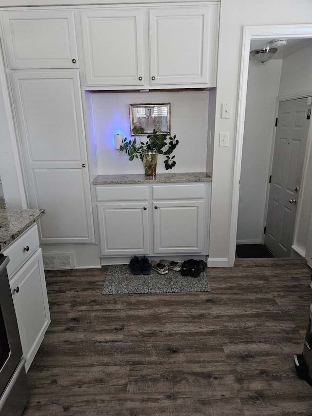 bar featuring dark wood finished floors, range, and baseboards