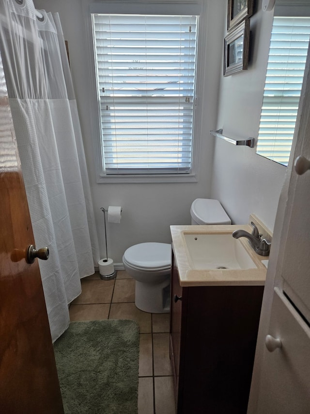 full bath featuring tile patterned flooring, curtained shower, baseboards, toilet, and vanity