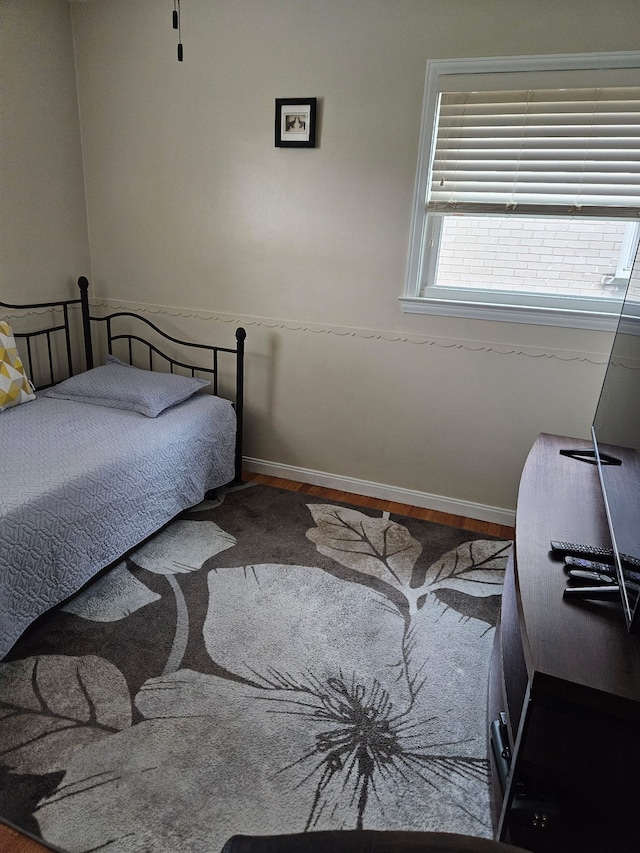 bedroom featuring baseboards and wood finished floors