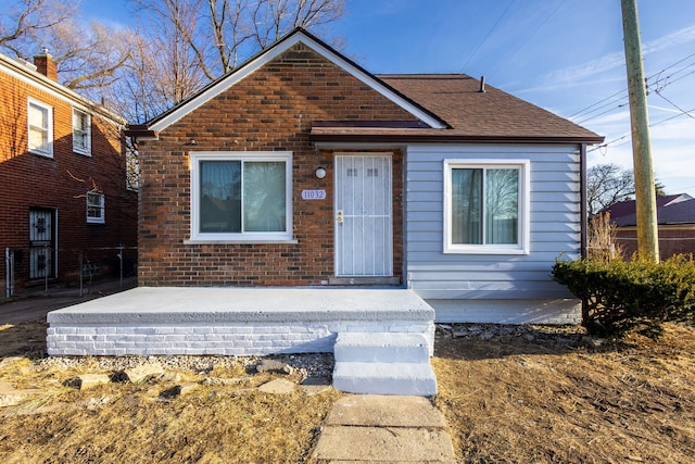 bungalow featuring roof with shingles