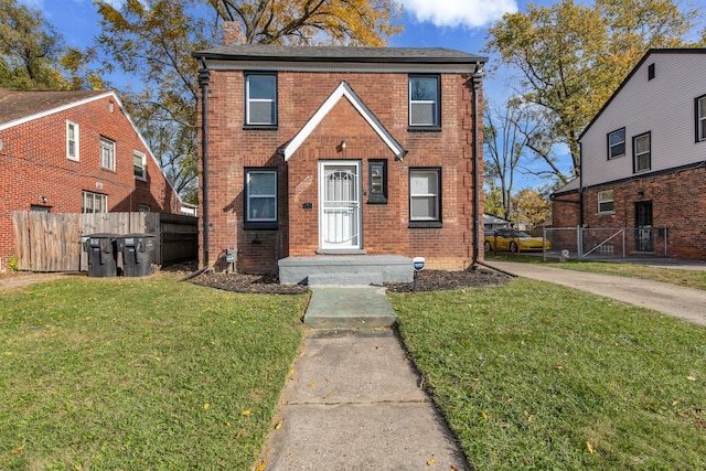 view of front of home featuring a front lawn, fence, and brick siding