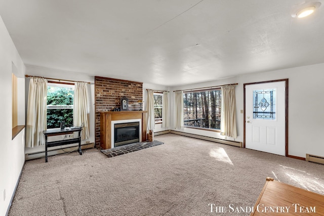 unfurnished living room featuring baseboard heating, carpet, and a glass covered fireplace