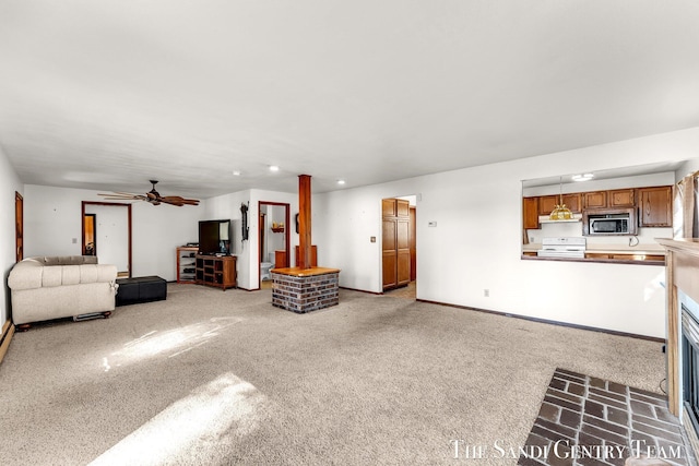 unfurnished living room with a fireplace, carpet flooring, a ceiling fan, and baseboards