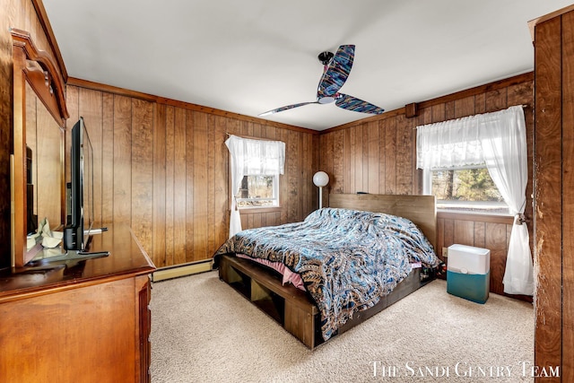 bedroom with wooden walls, multiple windows, baseboard heating, and carpet floors