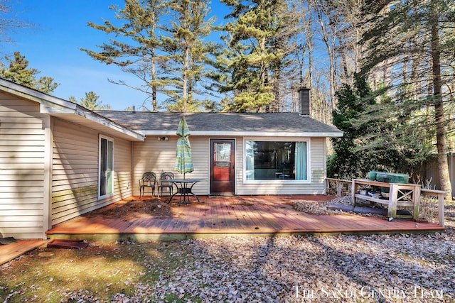 exterior space with a chimney and a wooden deck