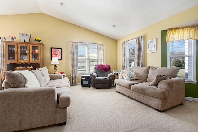 carpeted living area with vaulted ceiling, plenty of natural light, and baseboards