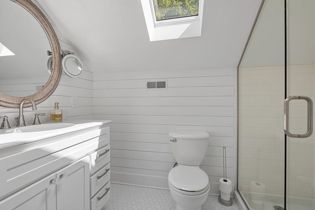 bathroom featuring visible vents, toilet, vaulted ceiling with skylight, a shower stall, and vanity