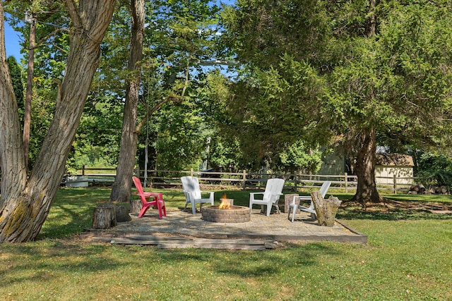 view of yard with fence and an outdoor fire pit