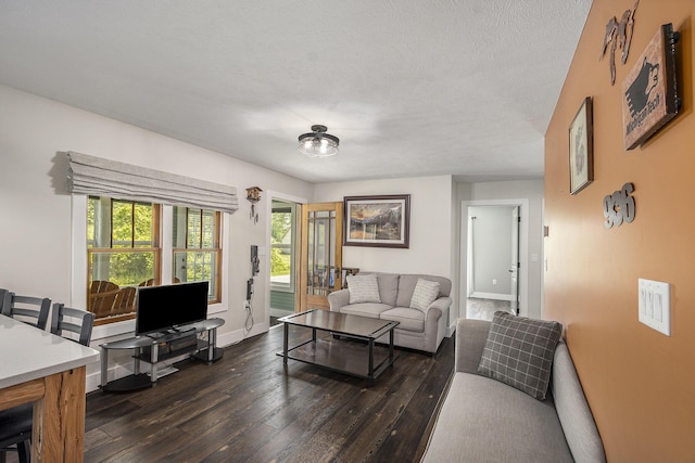 living area featuring dark wood-type flooring, baseboards, and a textured ceiling