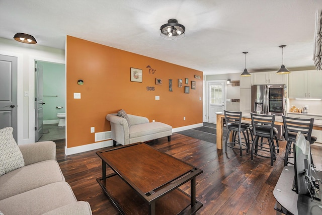 living area with visible vents, dark wood-style floors, and baseboards