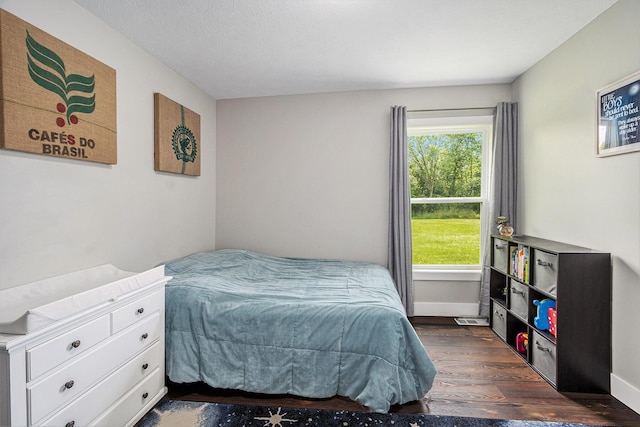 bedroom featuring dark wood finished floors and baseboards