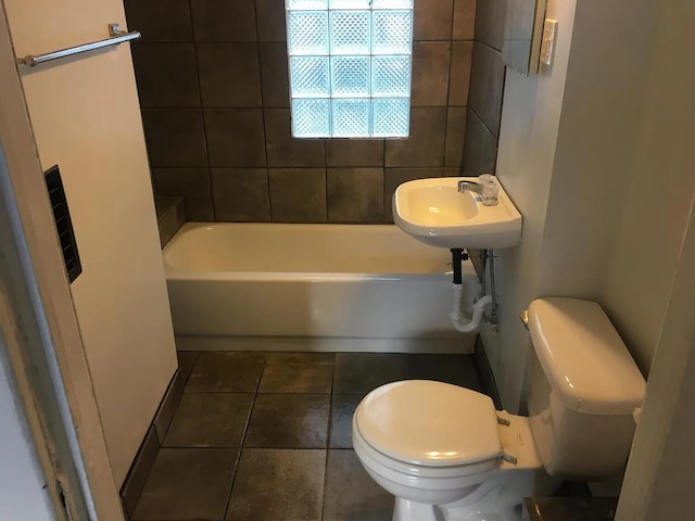 bathroom with tile patterned floors, toilet, a tub, and a sink