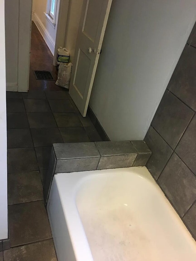 full bath featuring tile patterned flooring, a bath, and visible vents