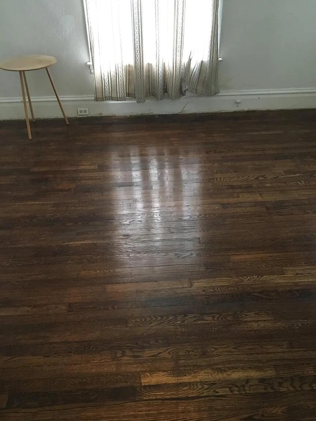 spare room with dark wood-style floors and baseboards