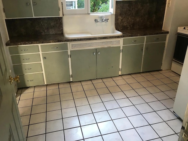 kitchen featuring a sink, backsplash, and light tile patterned floors