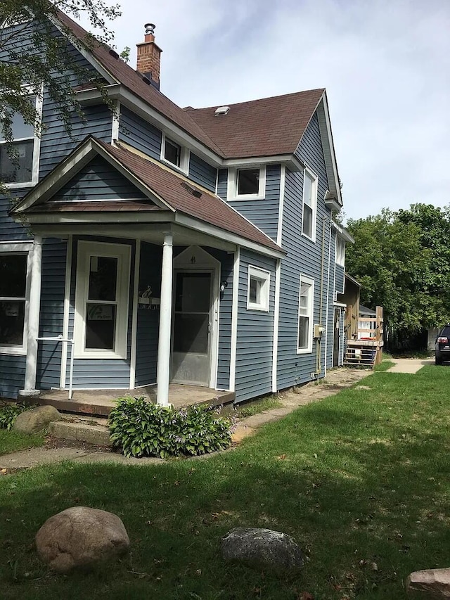 exterior space with a yard, a porch, and a chimney