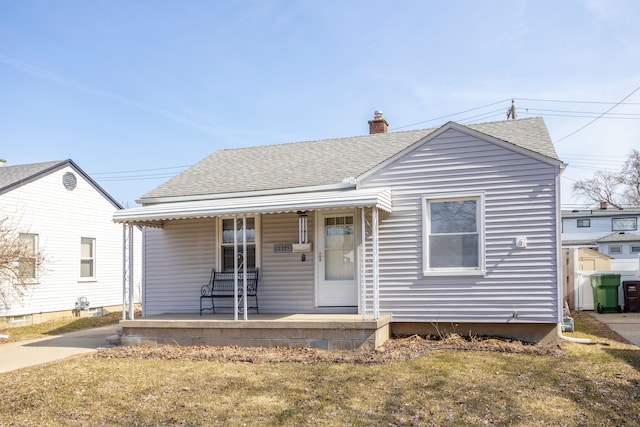 bungalow-style home with roof with shingles, a porch, and a chimney