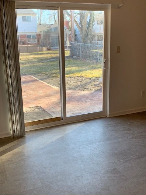 doorway to outside with a healthy amount of sunlight, concrete floors, and baseboards