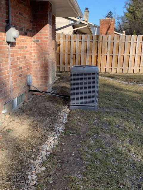 view of yard with central air condition unit and fence