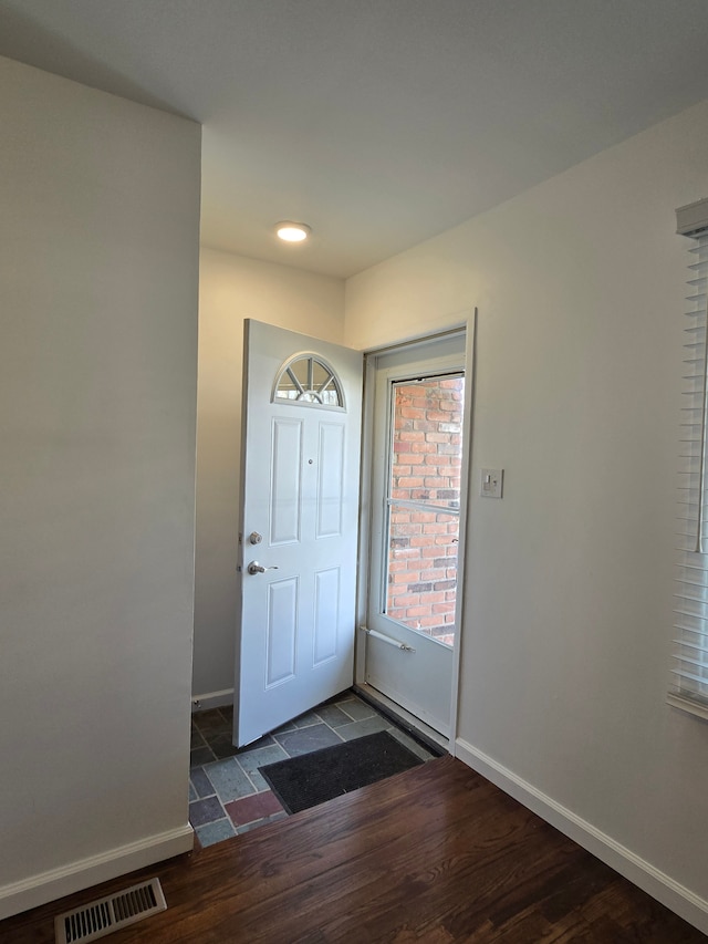 entrance foyer featuring dark wood finished floors, visible vents, and baseboards