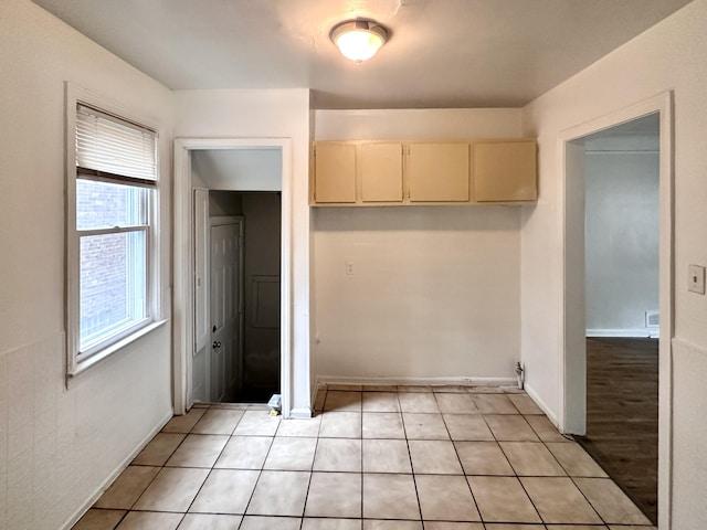 interior space with light tile patterned floors and baseboards