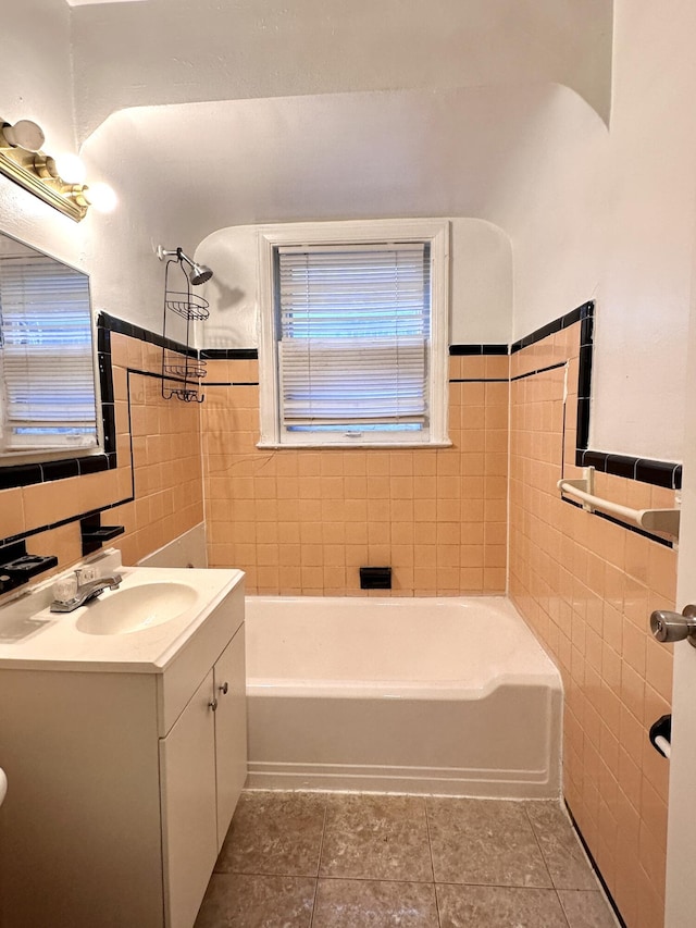 full bathroom featuring vanity, tile walls, tile patterned floors, and wainscoting