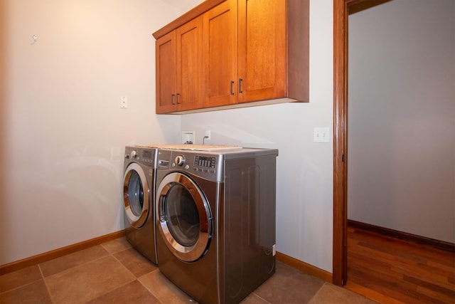 laundry area featuring tile patterned flooring, cabinet space, independent washer and dryer, and baseboards