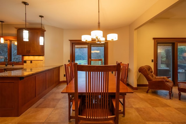 dining area with baseboards, an inviting chandelier, and light tile patterned flooring