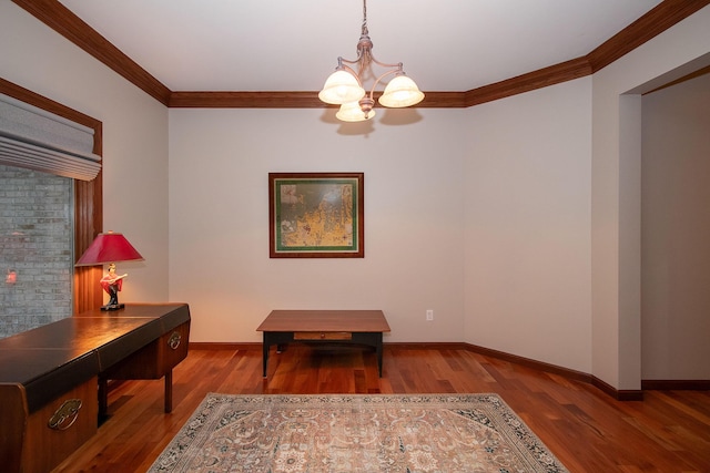 office area featuring an inviting chandelier, crown molding, wood finished floors, and baseboards