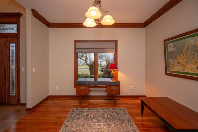 interior space with baseboards, wood finished floors, and ornamental molding