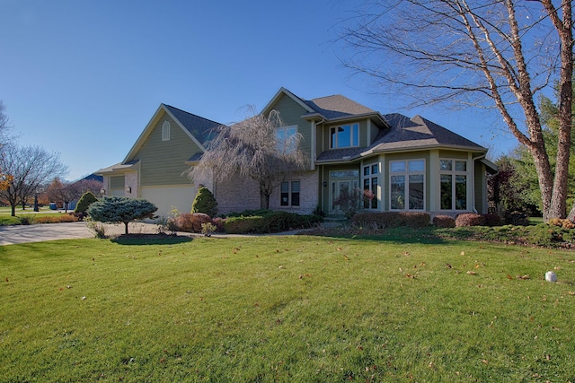 view of front of home with a front lawn, a garage, and driveway