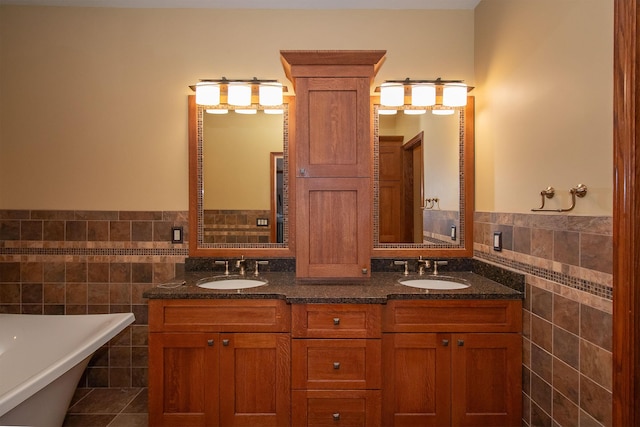 full bathroom featuring a freestanding bath, tile walls, and a sink