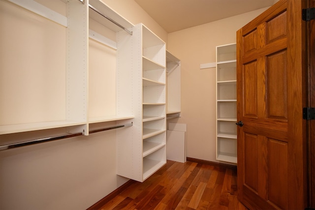 spacious closet with dark wood-type flooring