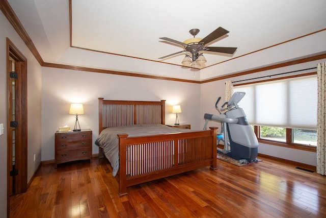 bedroom featuring hardwood / wood-style floors, baseboards, visible vents, ceiling fan, and ornamental molding